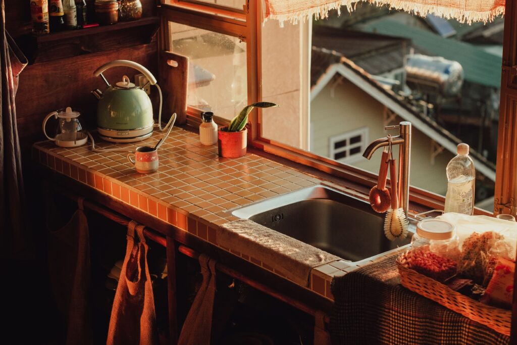 A warm home kitchen counter lit by natural light through a window