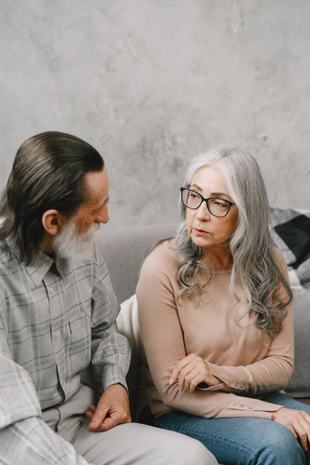 Senior couple sharing a quiet, thoughtful conversation at home
